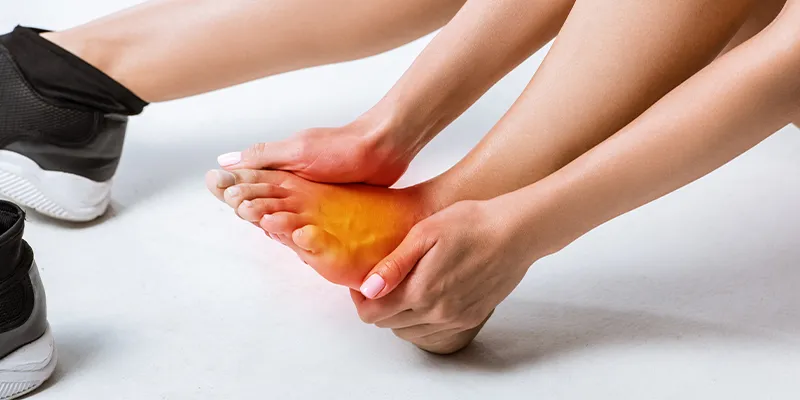 Person experiencing foot pain caused by an issue with their gait.
