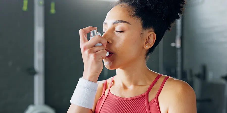 Woman using inhaler for asthma